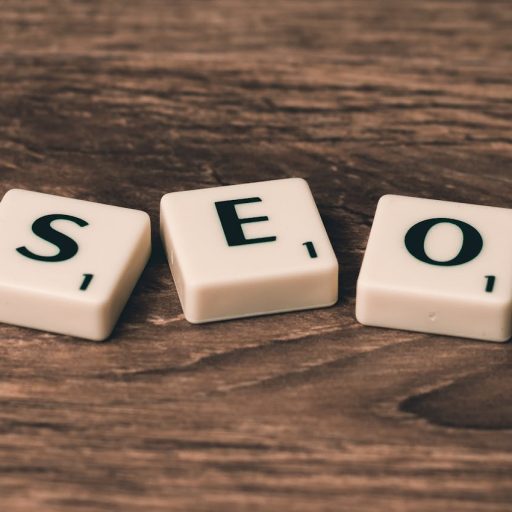 Scrabble tiles spelling 'SEO' on a wooden surface. Ideal for digital marketing themes.